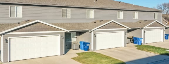 a home with two garages and a street in front of it