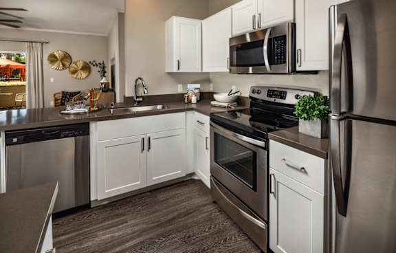 A modern kitchen with stainless steel appliances and white cabinets.