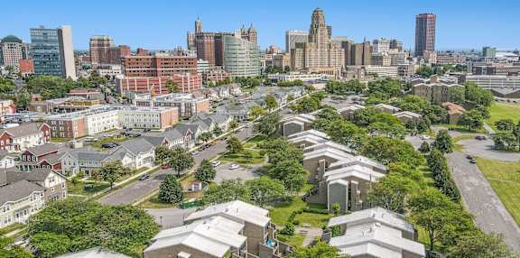 A view of a city from a high vantage point with buildings and a parking lot in the foreground at Shoreline Apartments, Buffalo, New York