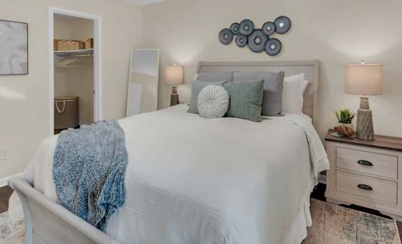 A bedroom with a bed, nightstand, and a ceiling fan.