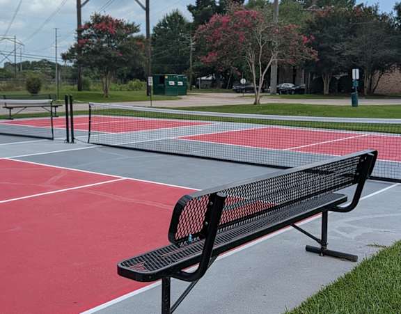 A black bench sits on a red track.