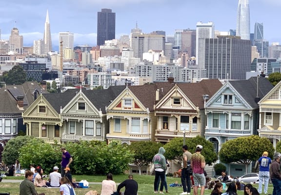 people congregate in front of the houses of the painted ladies in front