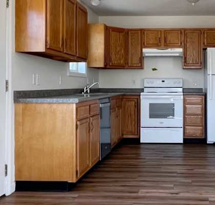 A kitchen with wooden cabinets and a white refrigerator.