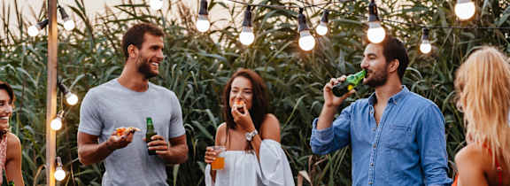 a group of people gathered around a table with food and drinks