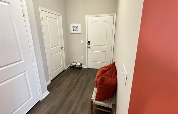 a living room with red walls and white doors at Watermark at Steele Crossing, Fayetteville, AR