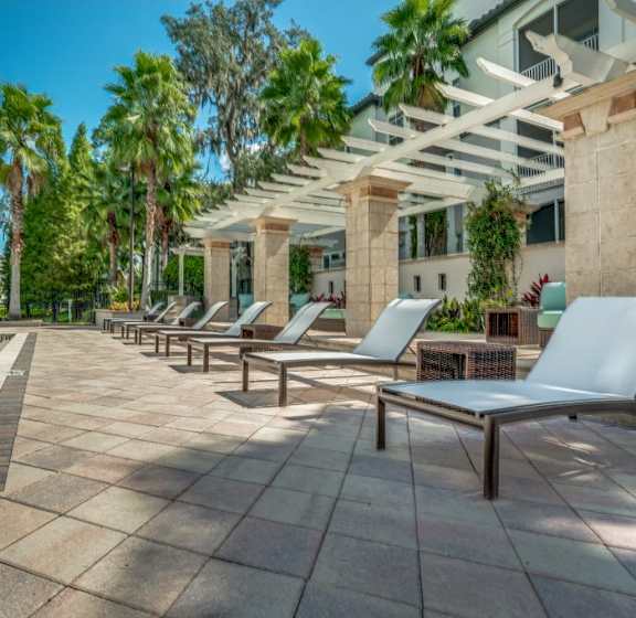 A pool surrounded by lounge chairs and umbrellas.