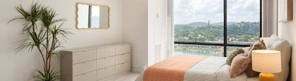 A bedroom with a large bed and a view of the city.