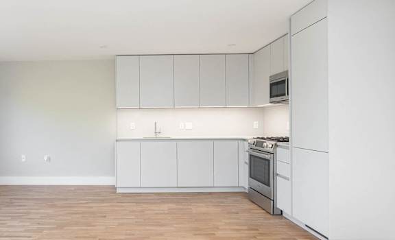 Open concept dining and living rooms with hardwood floors and ample natural light