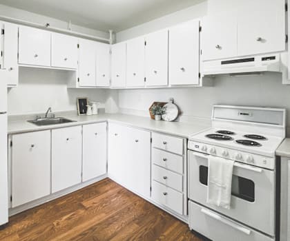 A kitchen with white appliances and cabinets.