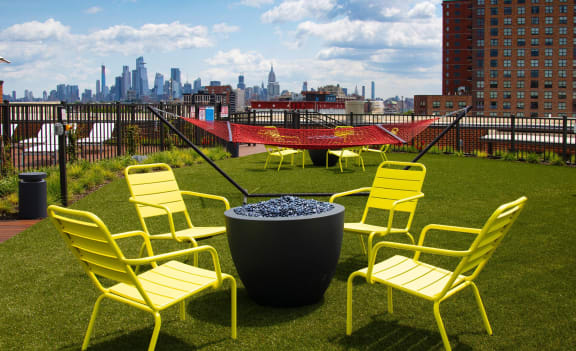 a group of yellow chairs sitting around a fire pit at The Enclave, Jersey City, New Jersey