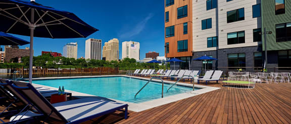 a pool with chairs and umbrellas next to a building at Dey & Bergen, Harrison, 07029