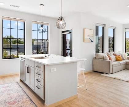 a kitchen with an island and a living room with a couch and a coffee table