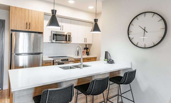 A Kitchen With a Clock On The Wall at Cadence at Griesbach, Alberta, T5E 1Y8