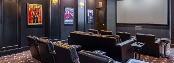 a theater room with leather seats and a projector screen