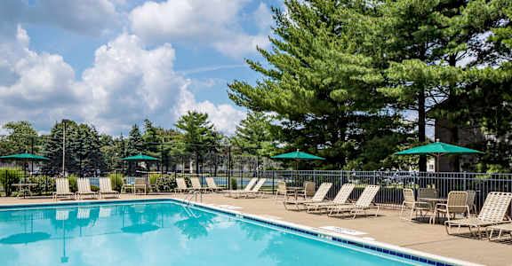 A large swimming pool surrounded by trees and lounge chairs. at Quail Ridge, Plainsboro Township, NJ, 08536