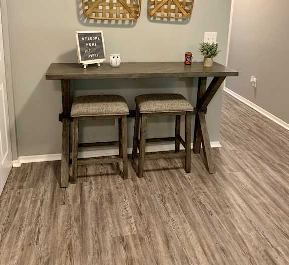 A wooden table with two chairs and a sign that says