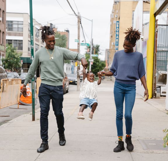 two women and a child walking down a city sidewalk