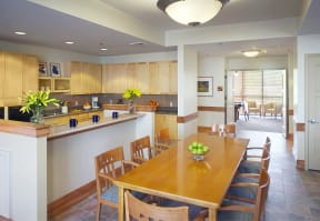 a kitchen and dining room with a wooden table and chairs at Cahill House Senior Apartments in St. Louis, MO