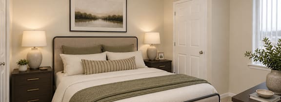 A bedroom with a large bed and a painting on the wall.