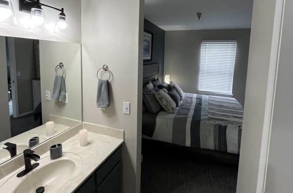 a bathroom with a sink and a mirror at The Lodge Apartments, Tulsa