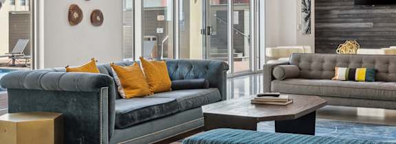 A living room with a blue couch and a wooden coffee table.