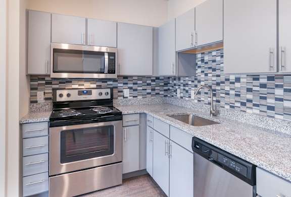 A kitchen with a stove, oven, microwave, and dishwasher.