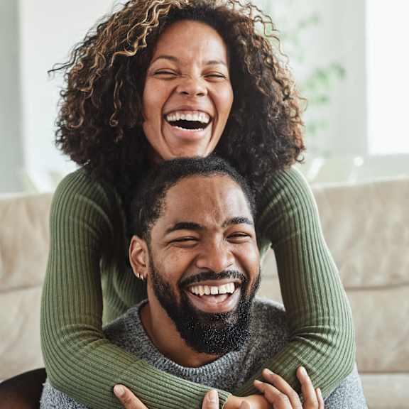 A man is hugging a woman from behind.