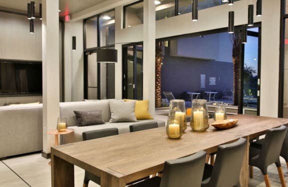 Luxury Apartments Scottsdale-Dusk Scottsdale Clubhouse Next to the Pool with Dining Table and Large Flat Screen TV