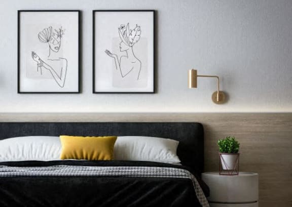 a bedroom with a bed and two pictures on the wall