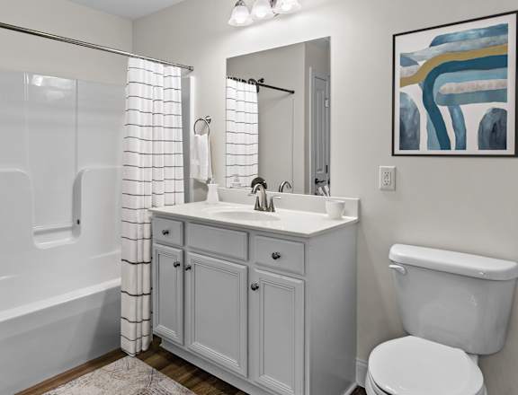 a white bathroom with a shower toilet and sink