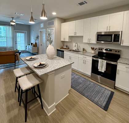 A kitchen with a white countertop and a stove top oven.