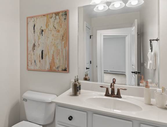a bathroom with a white sink and toilet and a shower