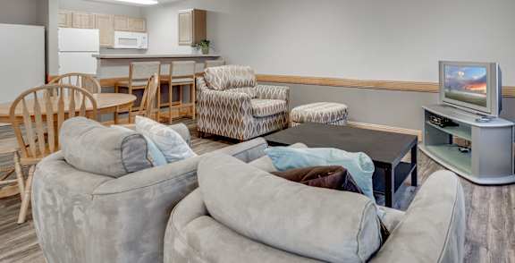 A living room with a television, couches, and chairs.