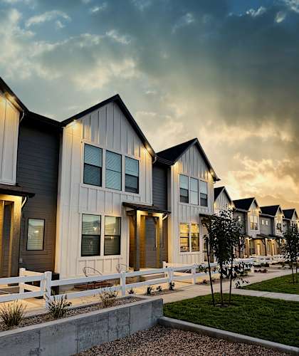 a row of houses with a cloudy sky in the background