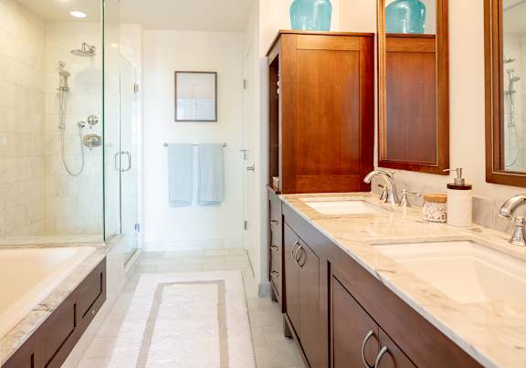 A bathroom with a glass shower stall and a white bathtub.