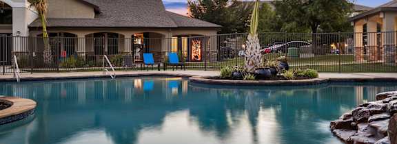 A large house with a pool in front.
