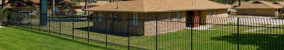 A sign that says "Woodlands" is in front of some houses.