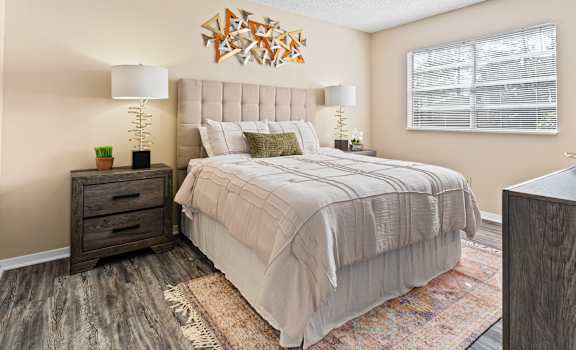 A bedroom with a large bed and a wooden dresser.