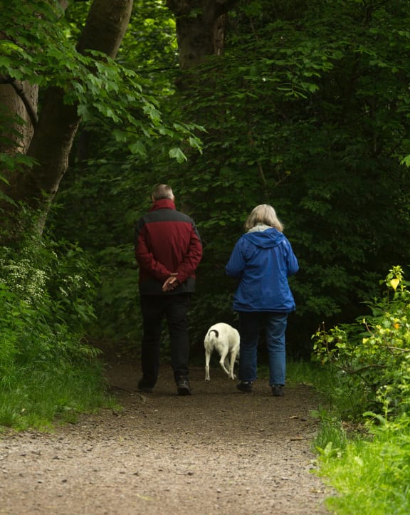 a man and a woman walking a dog on a trailat Ovation at Meeker, Kent Washington
