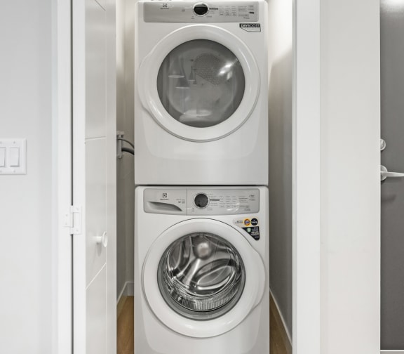 a white washer and dryer in a white closet