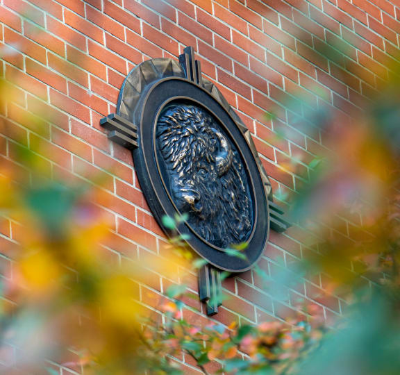 a black statue on the side of a brick wall