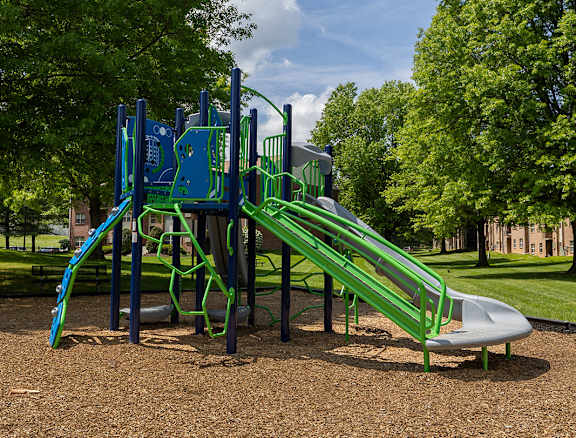 A playground with a green slide and a blue climbing frame.at Deer Park Apartments, Maryland, 21133