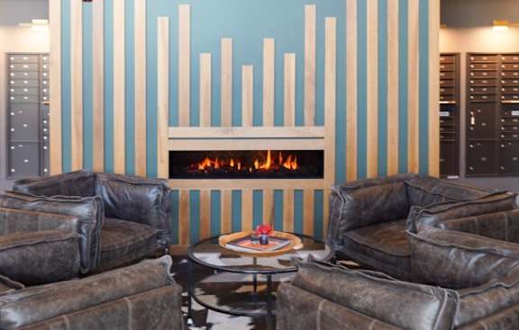 A living room with a fireplace and a clock on the wall.