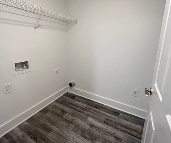 a room with wood flooring and a shelf on the wall