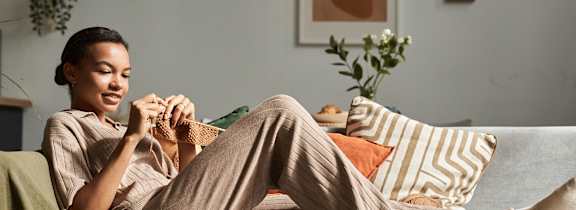 A couple is lying on a bed with pillows and a laptop.