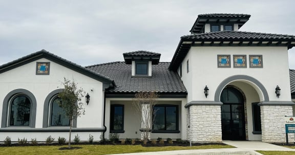 a white house with a tile roof and a driveway