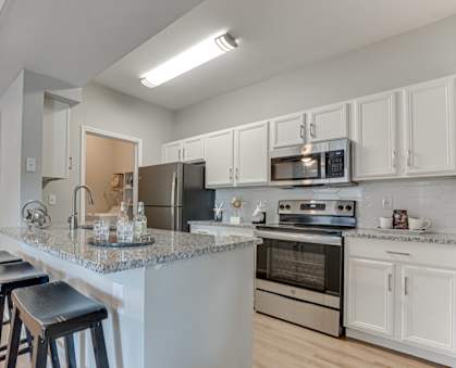 A kitchen with a bar area and stools.
