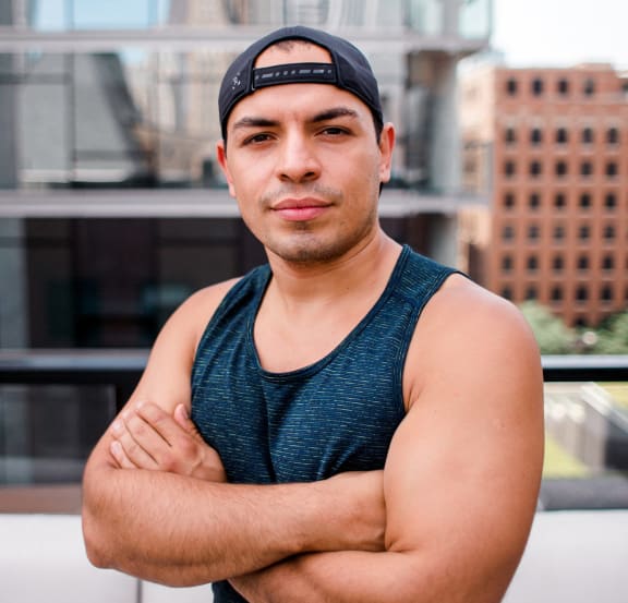 a man wearing a hat standing in front of a building