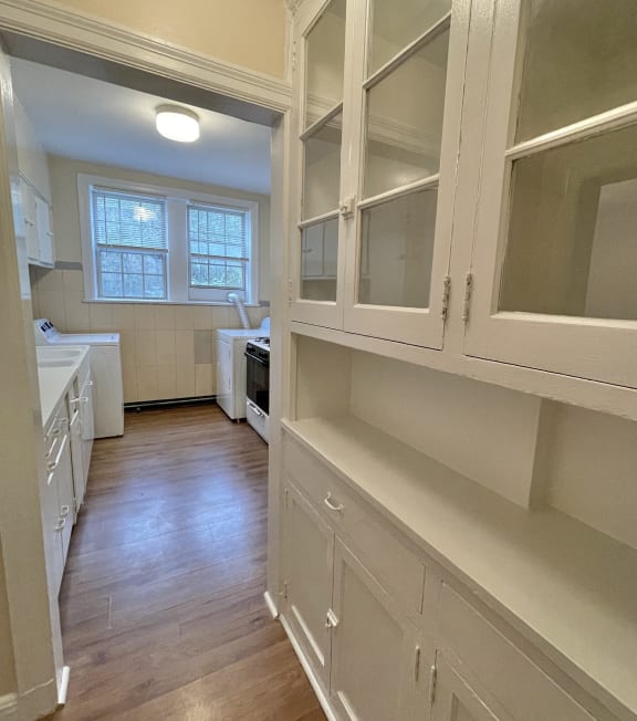 a kitchen with white cabinets and a wood floor