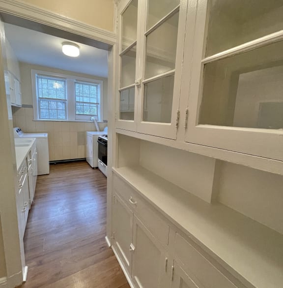 a kitchen with white cabinets and a wood floor